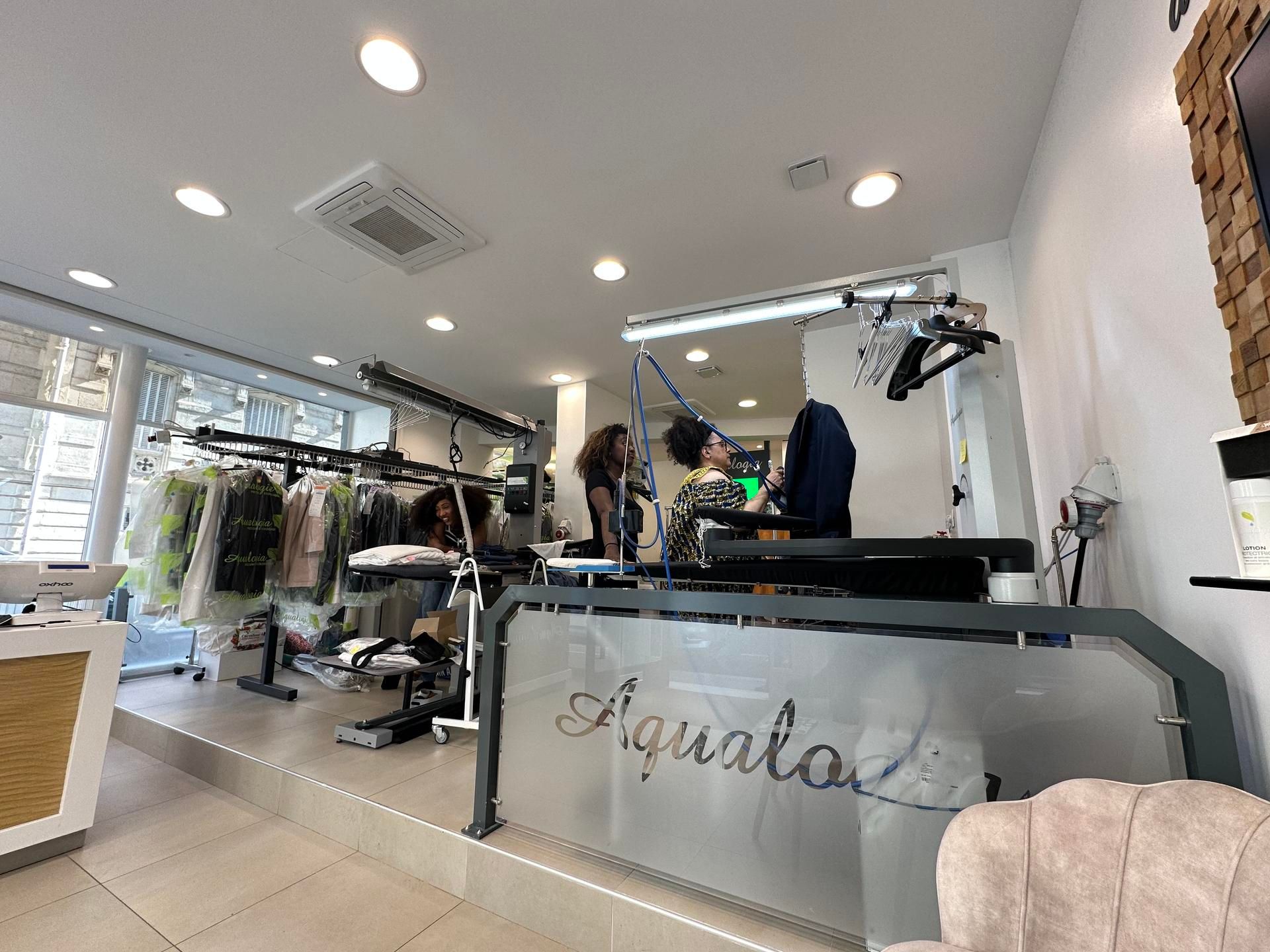Intérieur du pressing Aqualogia Paris 16 et espace de travail pour l’entretien des vêtements